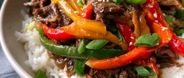 Healthy beef and pepper rice bowl with tender beef strips, colorful bell peppers, and fluffy rice, topped with fresh herbs.