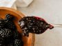 Homemade blackberry jam in a jar with fresh blackberries