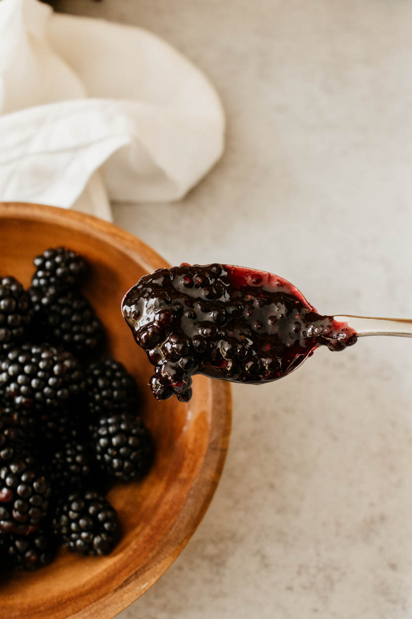 Homemade blackberry jam in a jar with fresh blackberries