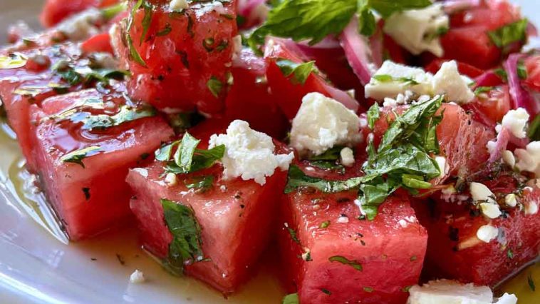 “Bowl of watermelon feta salad with fresh mint and lime dressing, served as a colorful summer side dish.”