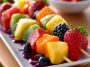 Fruit kabobs with strawberries, pineapple, and grapes – Colorful skewers of fresh fruit arranged on a platter.