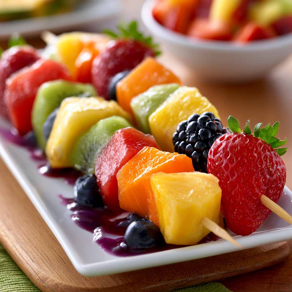Fruit kabobs with strawberries, pineapple, and grapes – Colorful skewers of fresh fruit arranged on a platter.