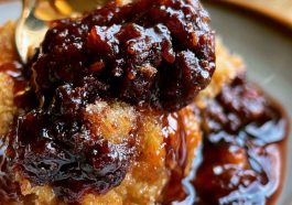 Warm Southern chocolate cobbler with a rich fudgy sauce beneath a soft chocolate cake topping, served with a scoop of vanilla ice cream.