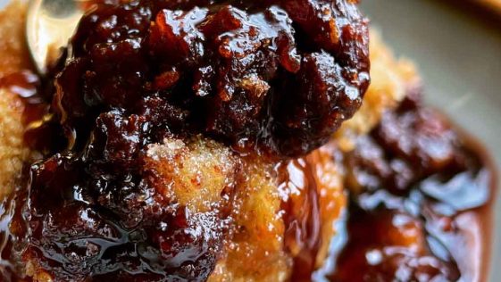 Warm Southern chocolate cobbler with a rich fudgy sauce beneath a soft chocolate cake topping, served with a scoop of vanilla ice cream.