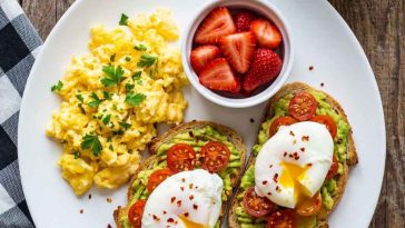 Healthy scrambled eggs with strawberries and avocado toast on a plate.Healthy Breakfast