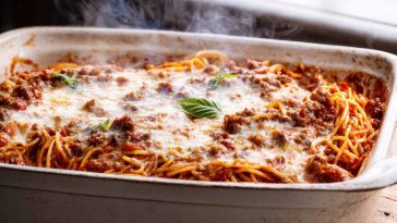 Million Dollar Spaghetti baked with melted cheese and meat sauce in a casserole dish.