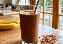 High-protein Healthy Chocolate Smoothie topped with cacao nibs, banana slices, and chia seeds.