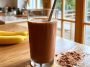 High-protein Healthy Chocolate Smoothie topped with cacao nibs, banana slices, and chia seeds.