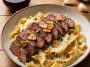 Garlic parmesan steak pasta – Creamy pasta tossed with garlic parmesan sauce and tender steak slices.